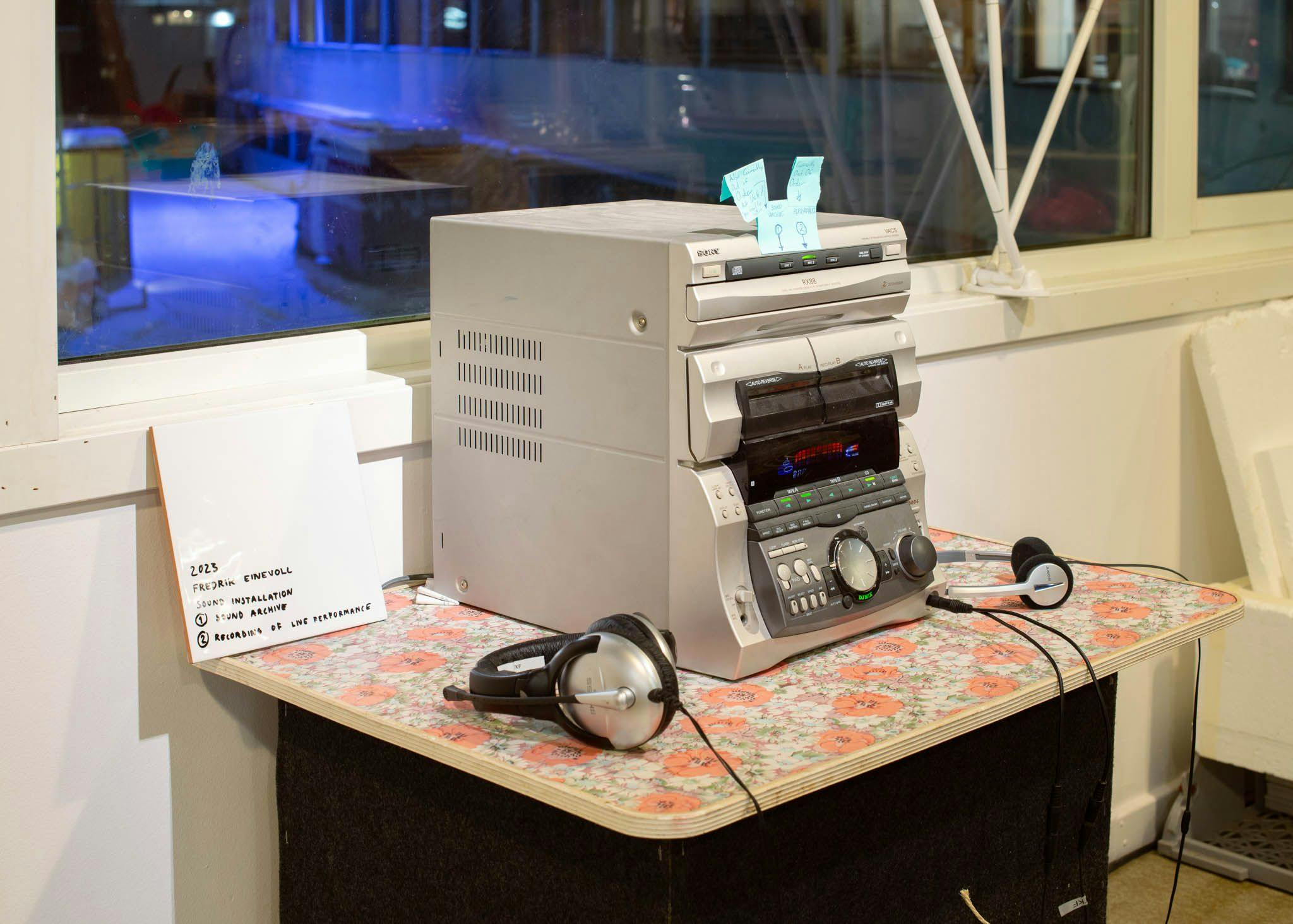 A retro hi-fi with two headphones. A sign tells 'Sound archive and recording of live performance'