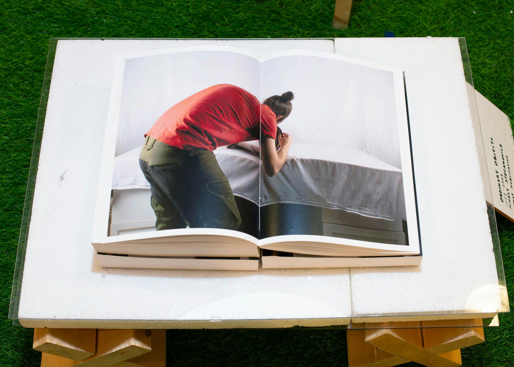 An open book shows a man bending over a table.
